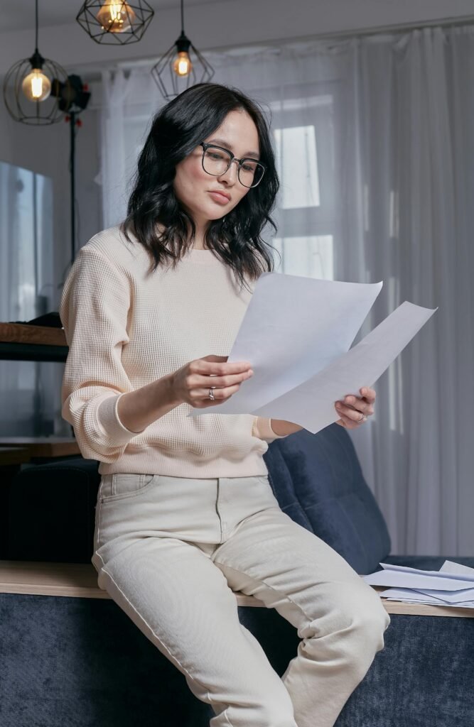 Woman in White Sweater Holding White Printer Paper